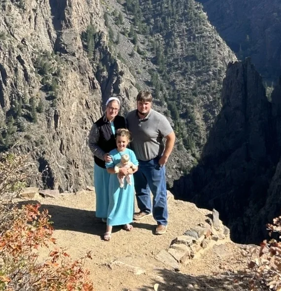 Joe, the owner of Solid Rock Fencing, with his wife and child at a mountain canyon overlook
