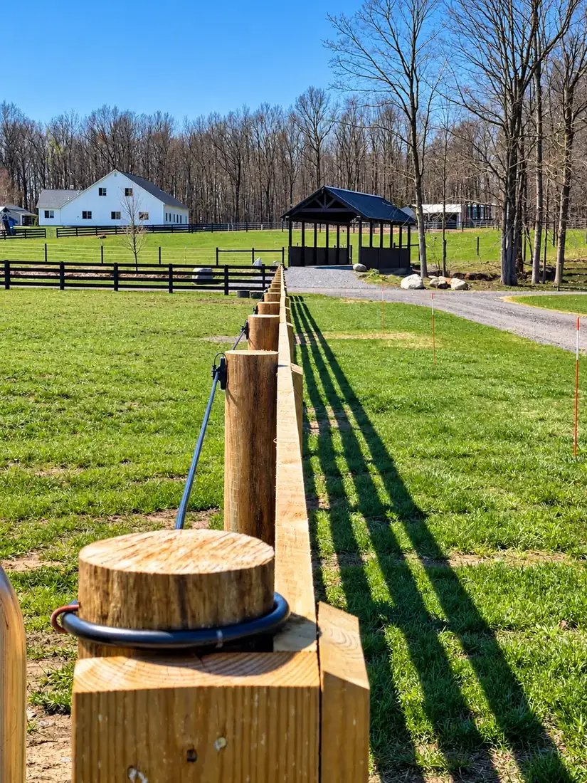 Heavy capped fence post and rail beside a pavilion