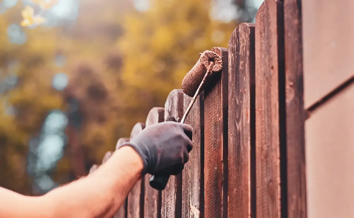 Painting a wood fence with a roller